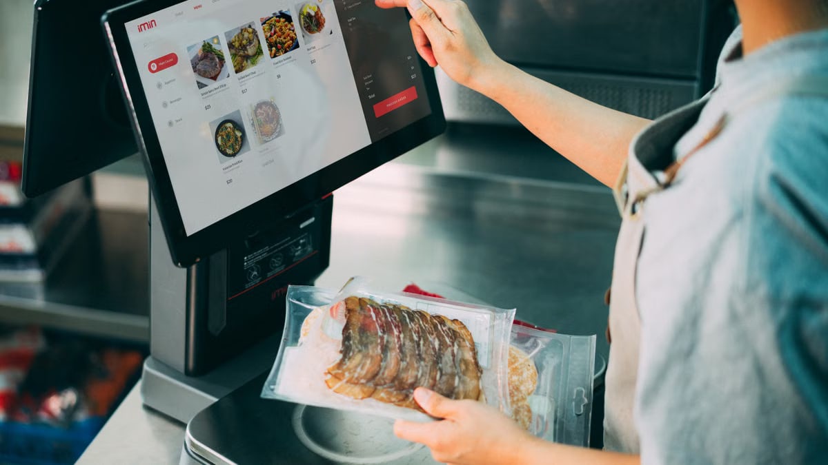 Person using digital POS system in a restaurant for cashless food payment.